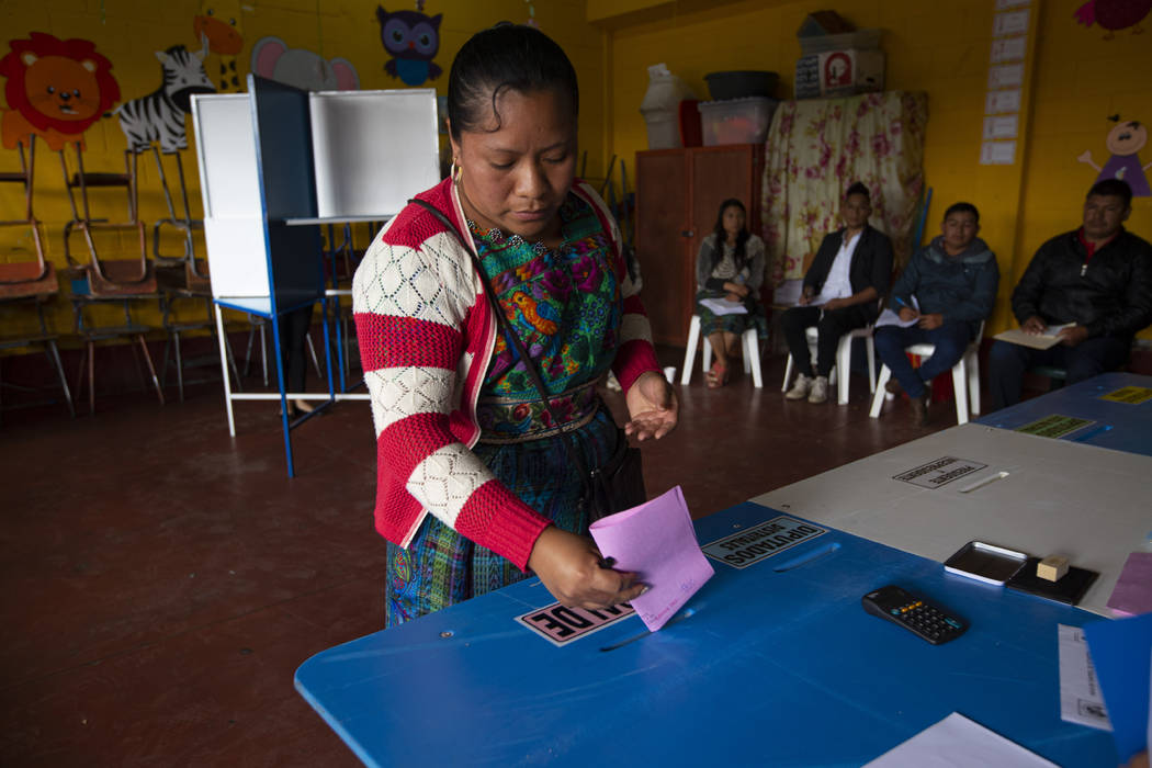 A indigenous woman casts her votes at a polling station in Sumpango, Guatemala, Sunday, June 16 ...