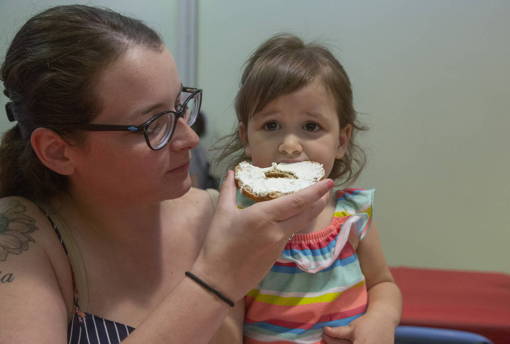 Savannah Castanon of Las Vegas feeds a bagel to her daughter Emilia, 3, during an event to cele ...