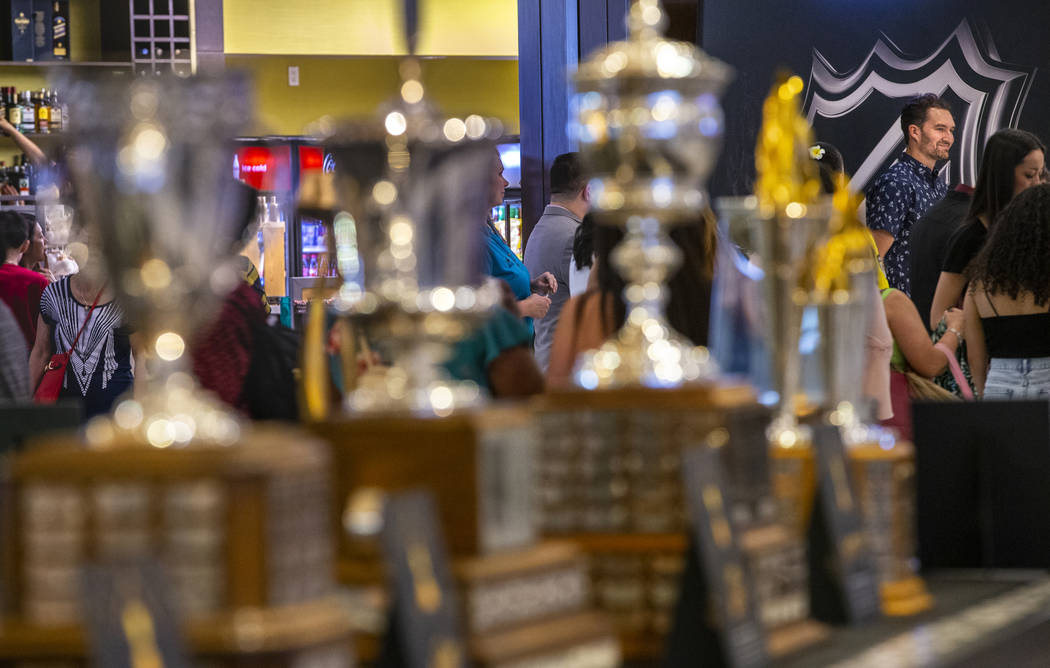 Golden Knights player Mark Stone looks to the line of fans with NHL trophies on display across ...