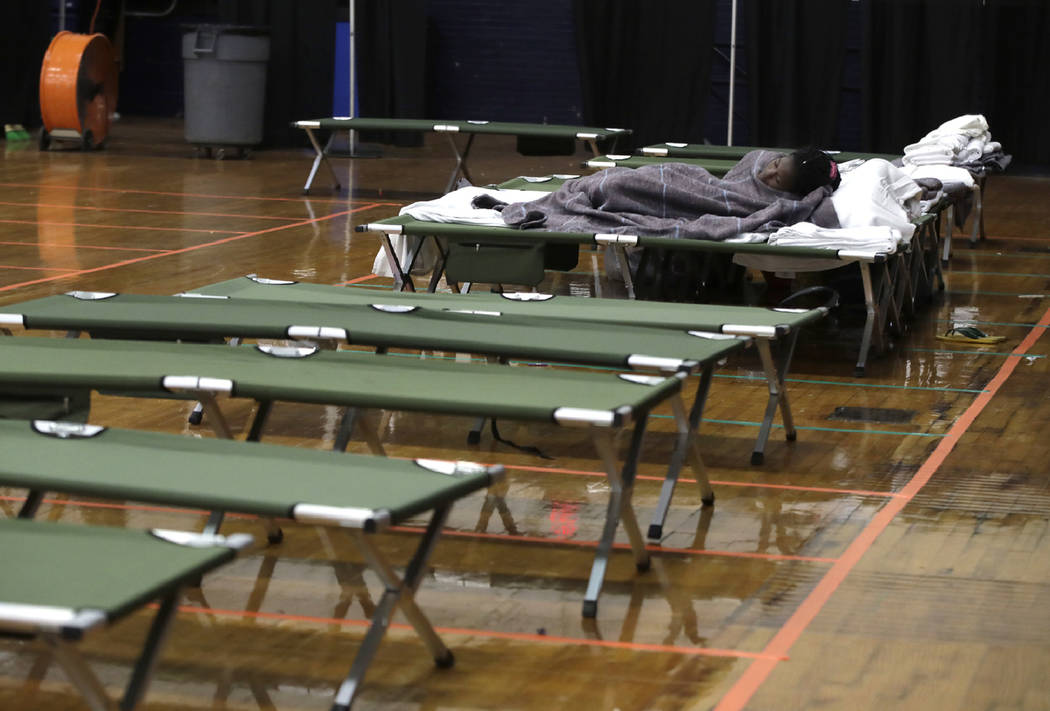 A migrant woman sleeps on a cot inside the Portland Exposition Building in Portland, Maine, on ...