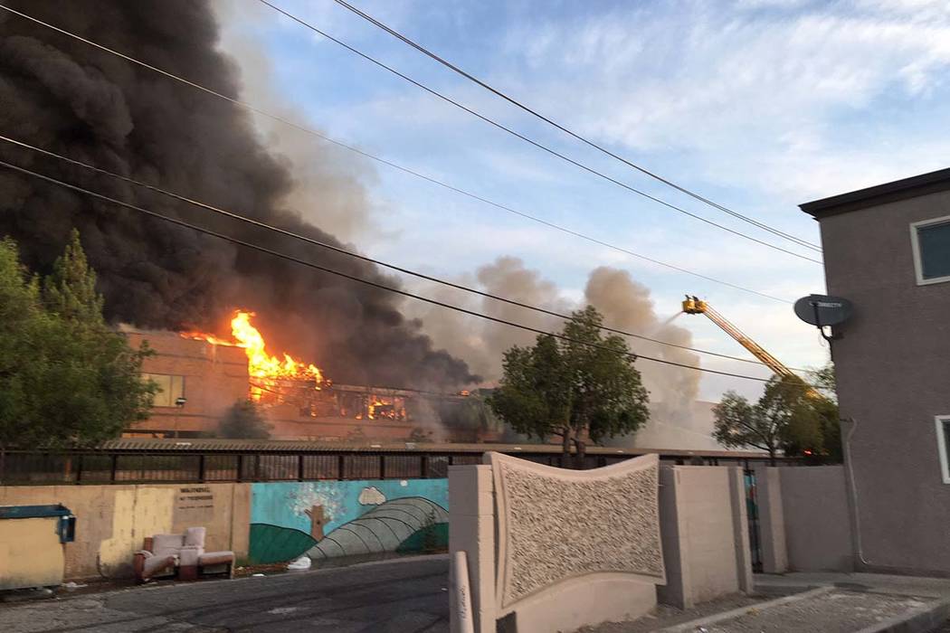 Heavy smoke and flames rise from a fire at a business complex near Paradise Road and East Twain ...