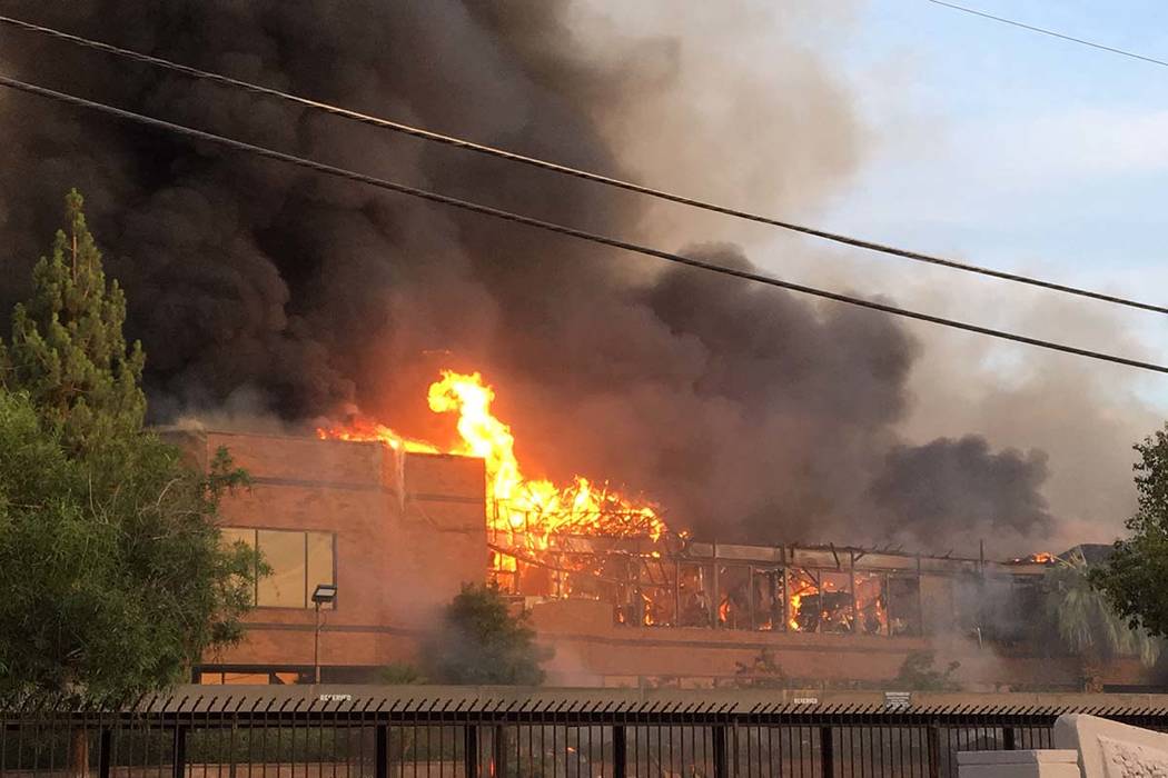 Heavy smoke and flames rise from a fire at a business complex near Paradise Road and East Twain ...