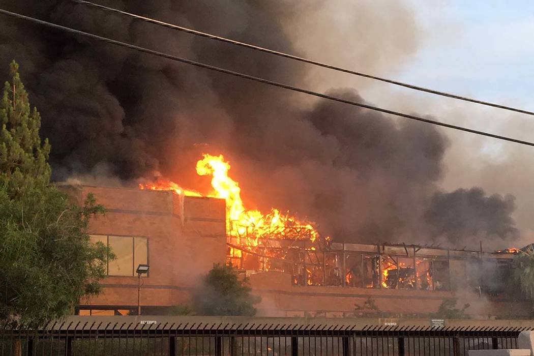 Heavy smoke and flames rise from a fire at a business complex near Paradise Road and East Twain ...