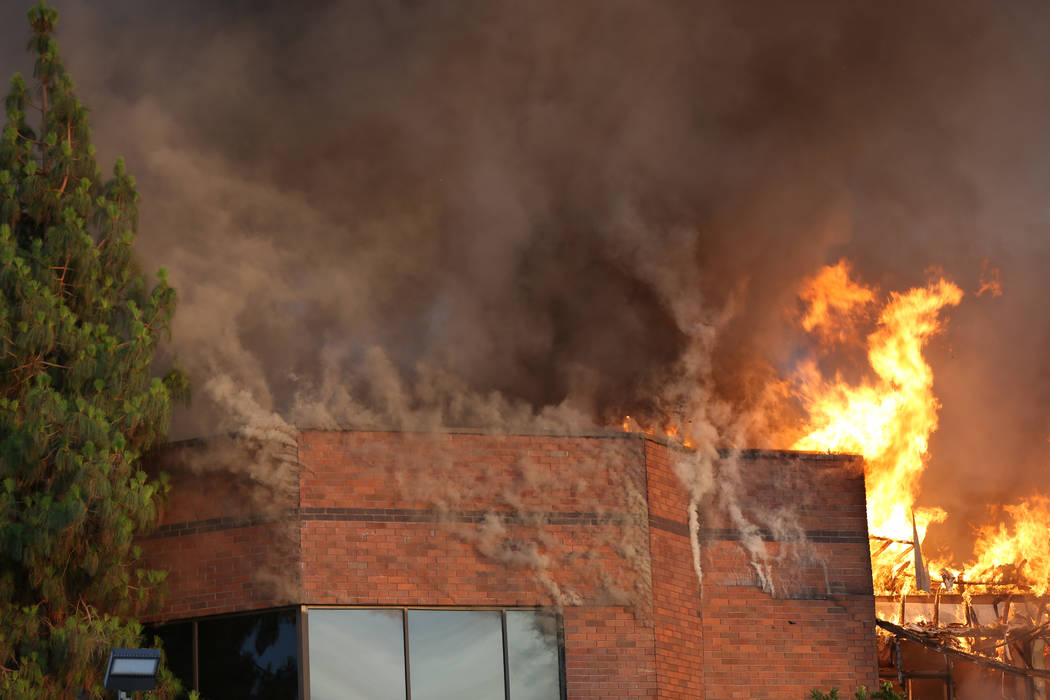 Heavy smoke and flames rise from a fire at a business complex near Paradise Road and East Twain ...