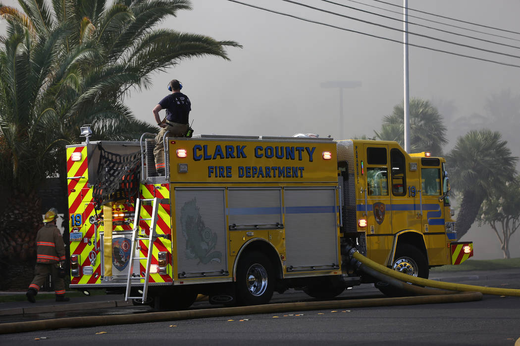 A firefighter watches from atop a Clark County Fire Department truck as an early morning fire e ...