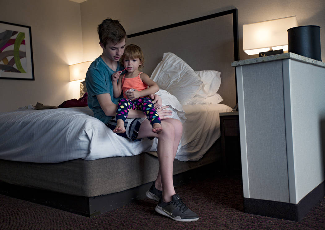 Weston Monson, 12, holds his sister Dixie Baalman, 2, at their family’s hotel room at the Sun ...