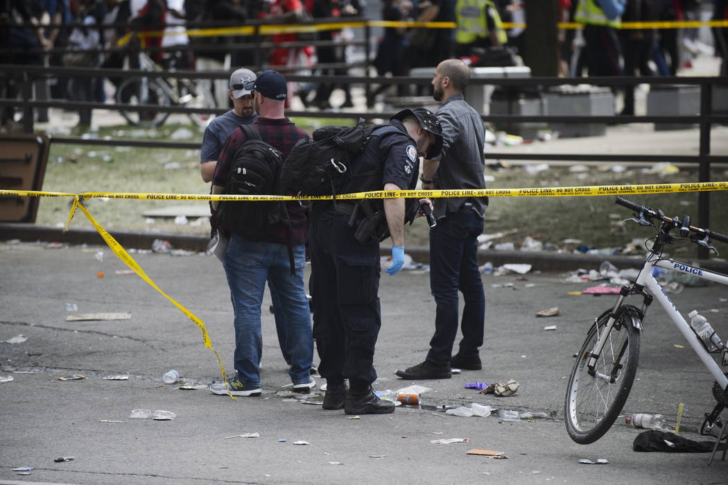 Toronto Police search for evidence after shots were fired during the Toronto Raptors NBA basket ...