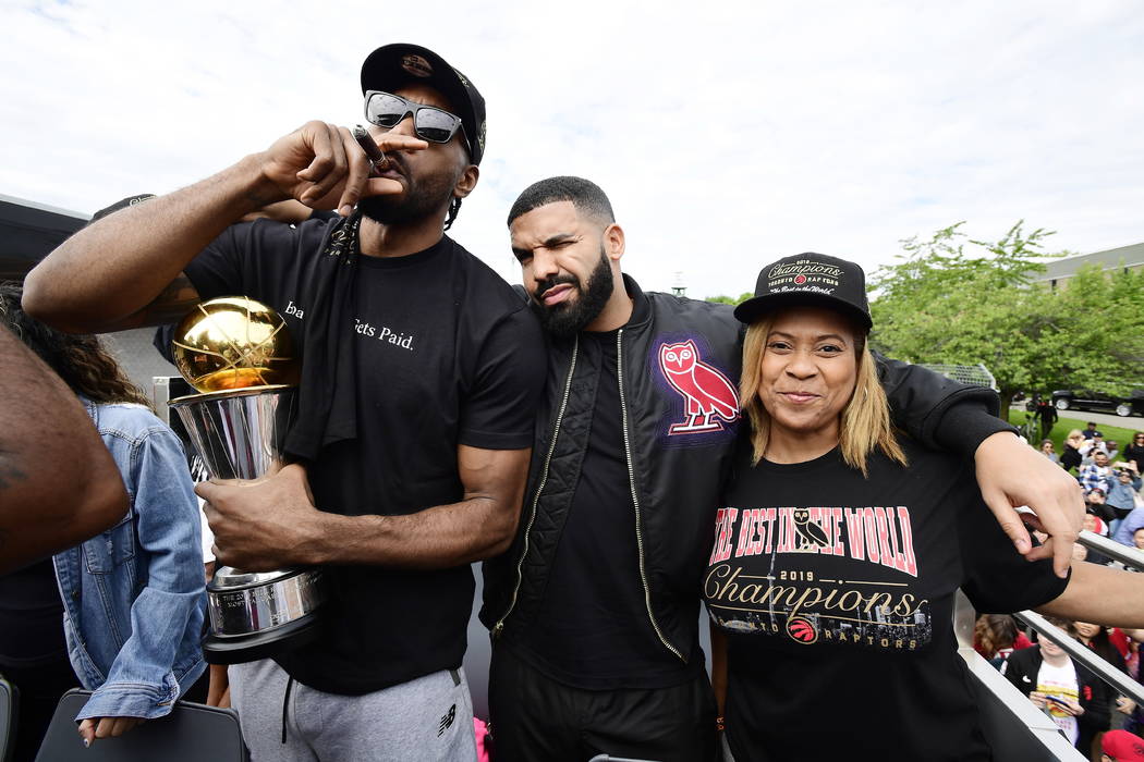 Toronto Raptors forward Kawhi Leonard, left to right, smokes a cigar holding his playoffs MVP t ...