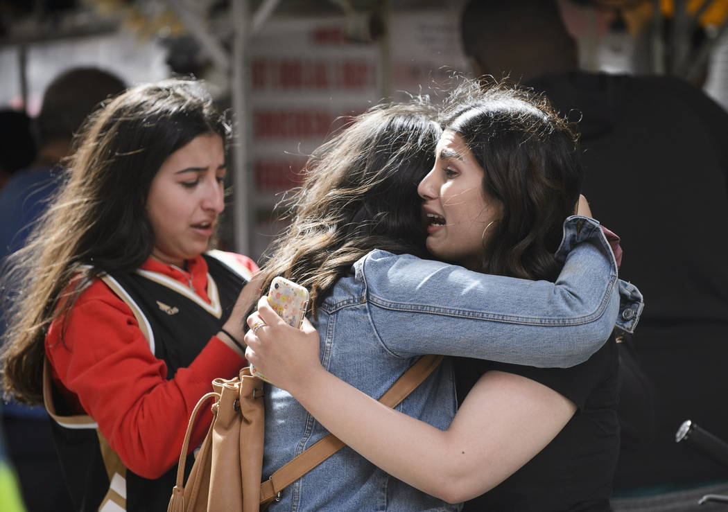 Friends embrace after shots were fired during the Toronto Raptors NBA basketball championship p ...