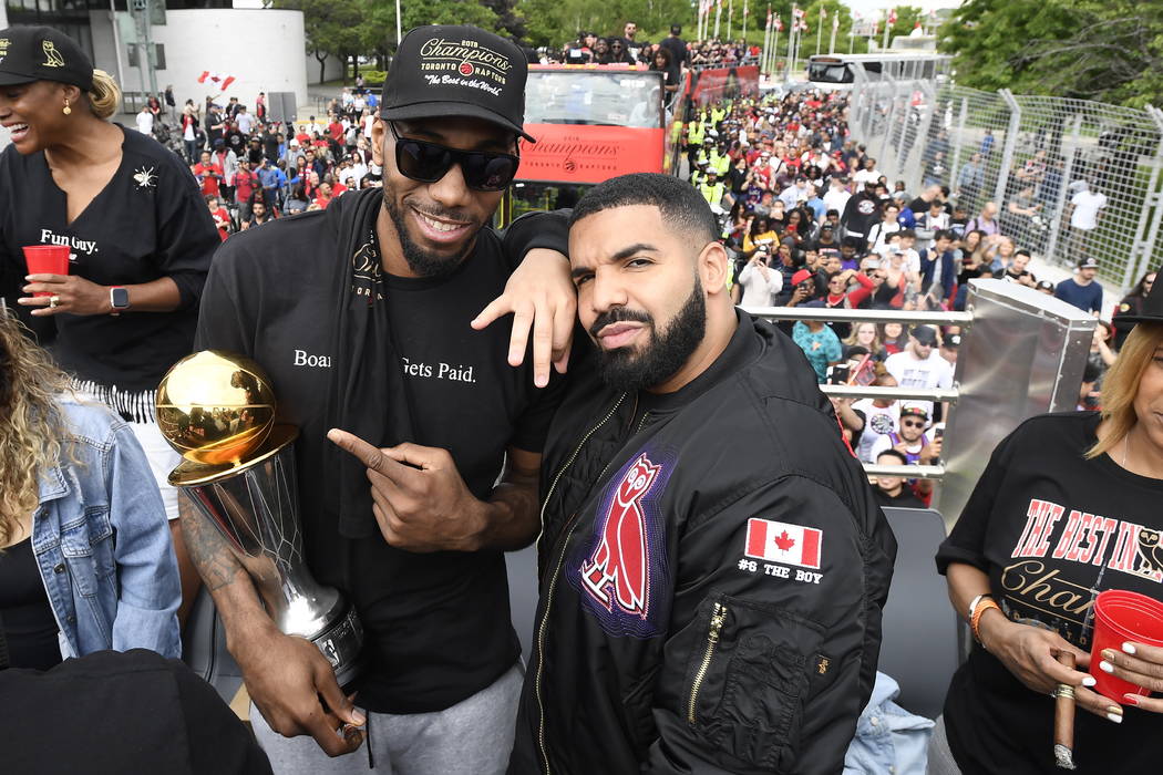 Toronto Raptors forward Kawhi Leonard points at his playoffs MVP trophy as he poses with perfor ...