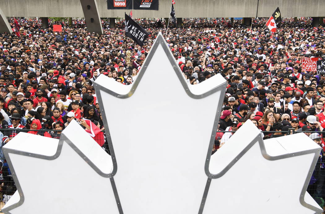 Fans gather to cheer on the Toronto Raptors during the NBA basketball team's championship parad ...