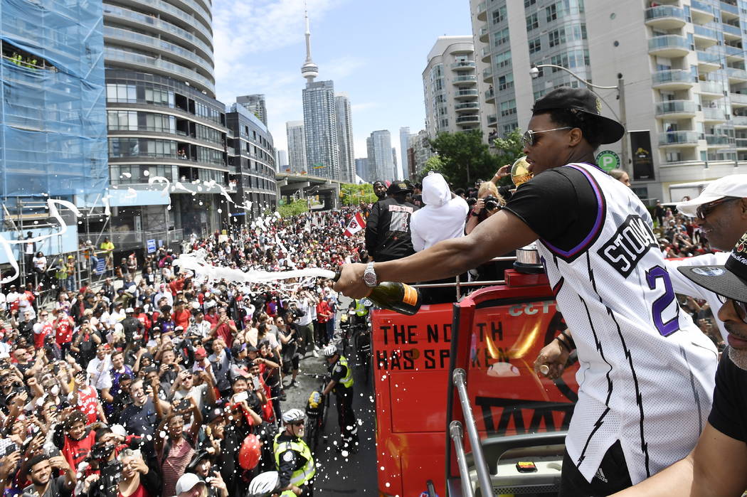 Toronto Raptors guard Kyle Lowry sprays champagne towards fans during the NBA basketball champi ...