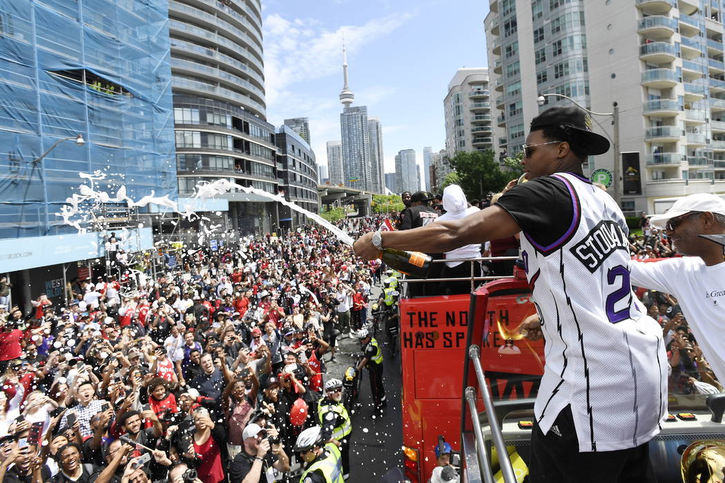 Toronto Raptors guard Kyle Lowry sprays champagne on fans during the NBA basketball championshi ...