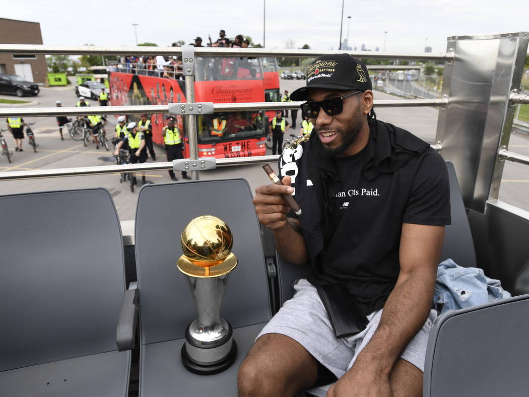 Toronto Raptors forward Kawhi Leonard smokes a cigar as he sits with his playoffs MVP trophy du ...