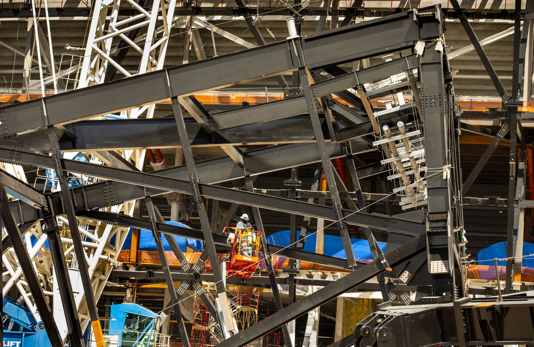 A crew in a lift examine a truss on the ground at Raiders Stadium where one of the 65-ton steel ...