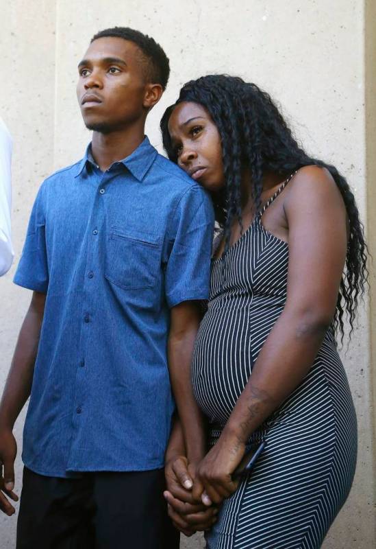 Dravon Ames, left, and Iesha Harper hold hands as they listen to a question during a news confe ...