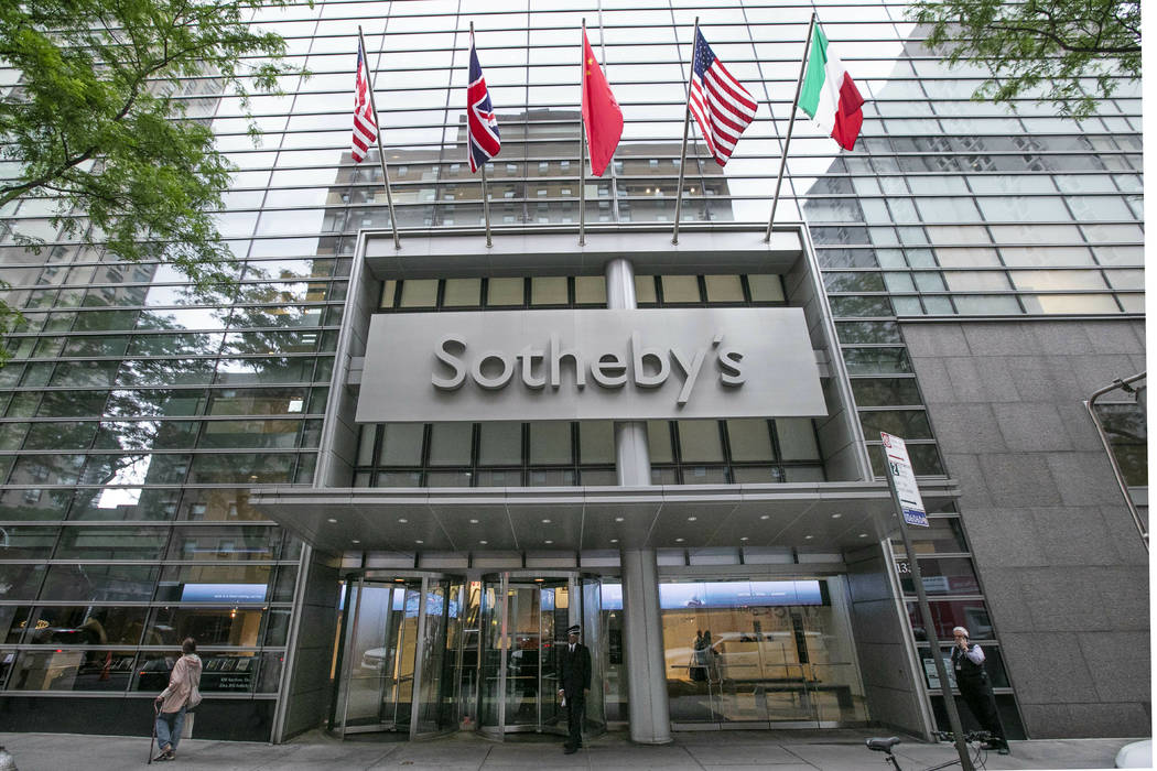 Flags fly on the front of Sotheby's auction house, in New York, Monday, June 17, 2019. BidFair ...