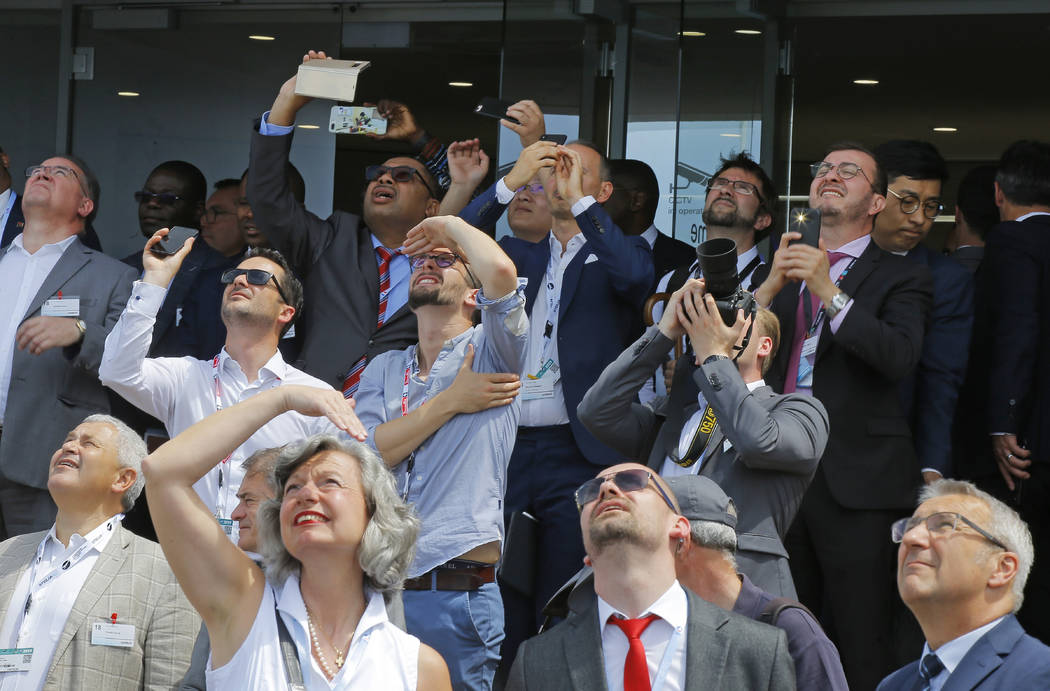 Visitors watch a demonstration flight at Paris Air Show, in Le Bourget, east of Paris, France, ...