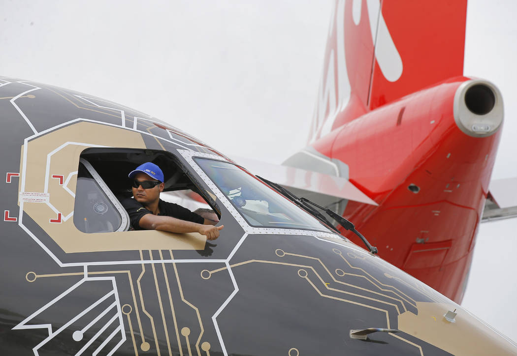 A pilot of an Embraer Profit Hunter E195-E2 makes the thumbs up sign as he on the tarmac at Par ...