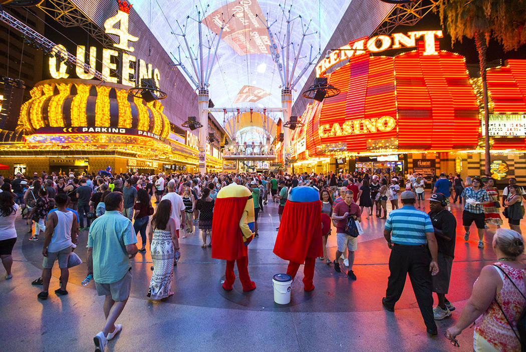 Buskers wait to pose with tourists for tips along the Fremont Street Experience in downtown Las ...