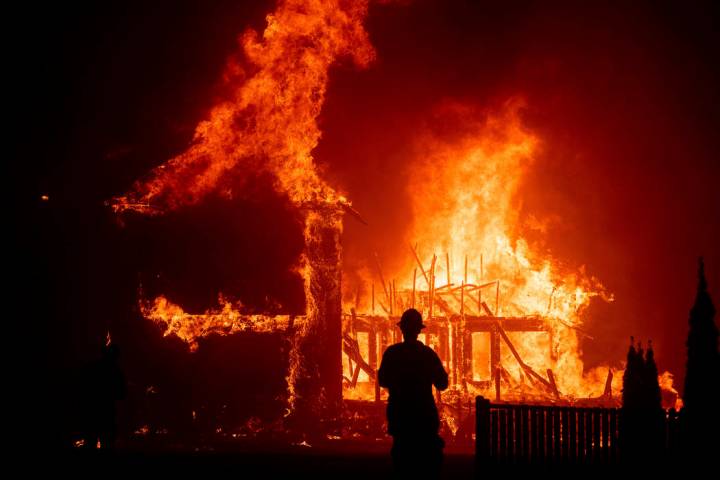 FILE - In this Nov. 8, 2018 file photo, a home burns as a wildfire called Camp Fire rages throu ...