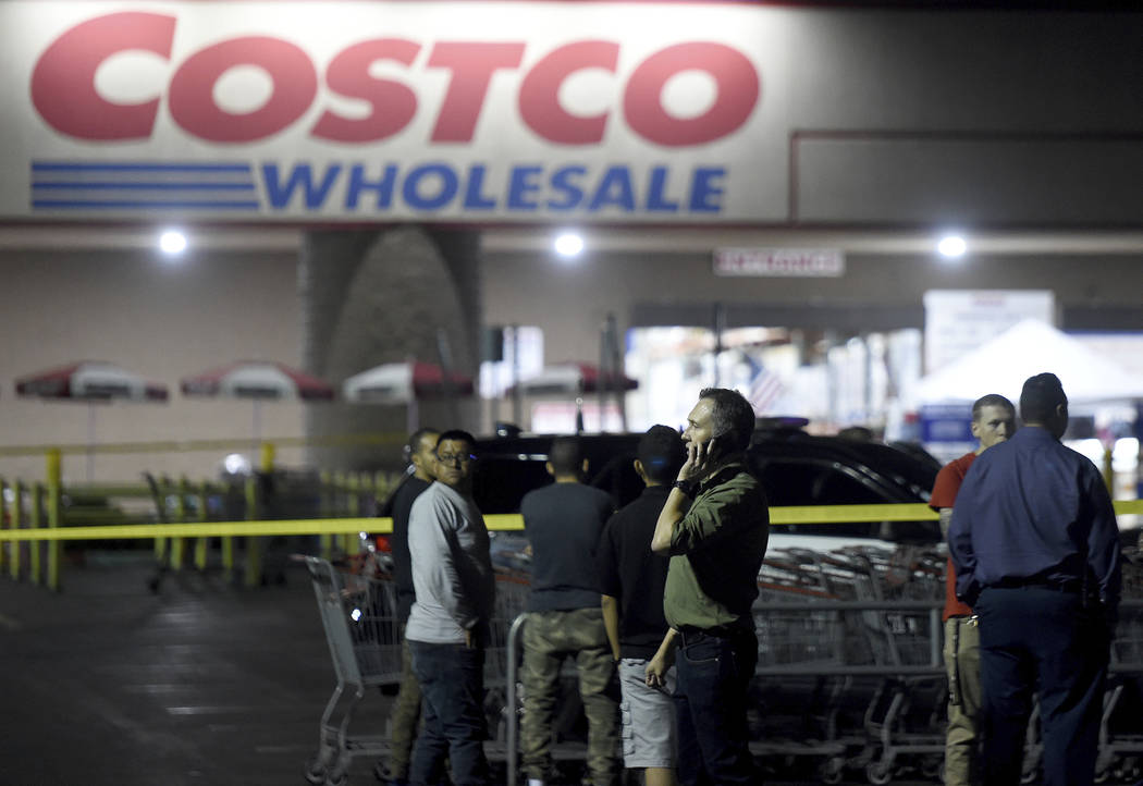 A Costco employee talks on the phone following a shooting within the wholesale outlet in Corona ...