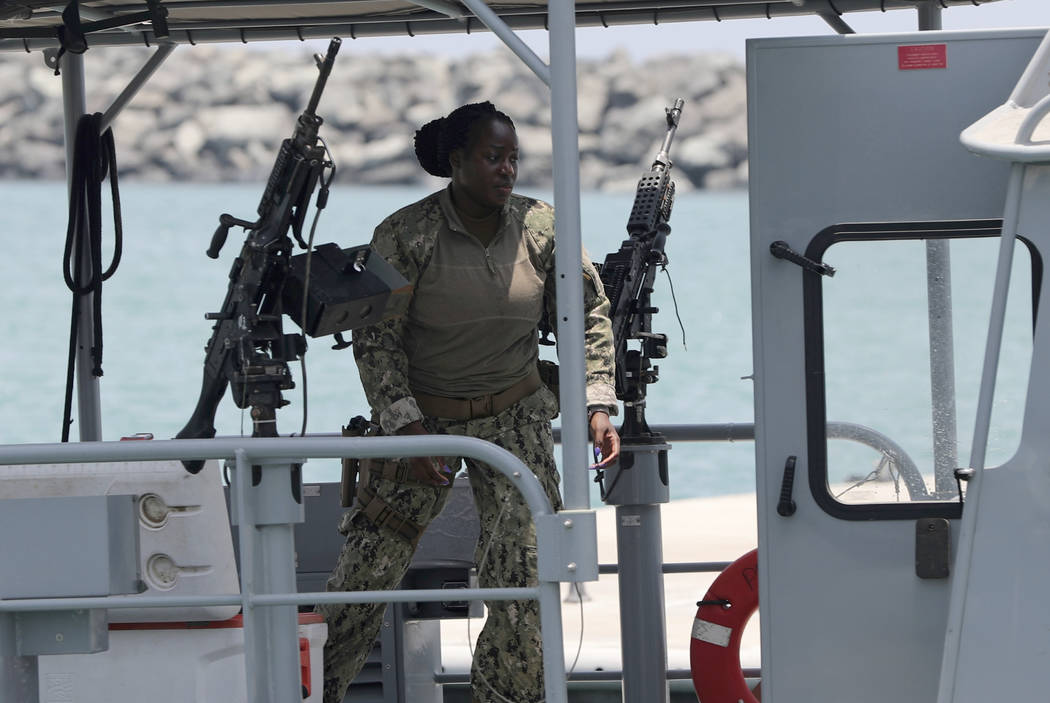 A U.S. Navy personnel prepares at a patrol boat to carry journalists to see damaged oil tankers ...