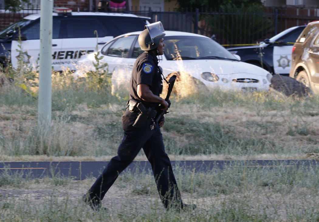 A Sacramento Police officer responds to the shooting of a fellow officer in Sacramento, Calif., ...