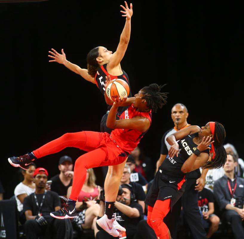 Washington Mystics guard Ariel Atkins (7) gets tripped up while going to the basket between Las ...