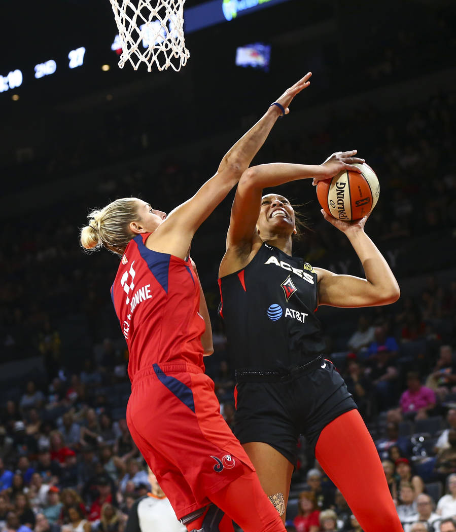 Las Vegas Aces center A'ja Wilson (22) goes to the basket under pressure from Washington Mystic ...