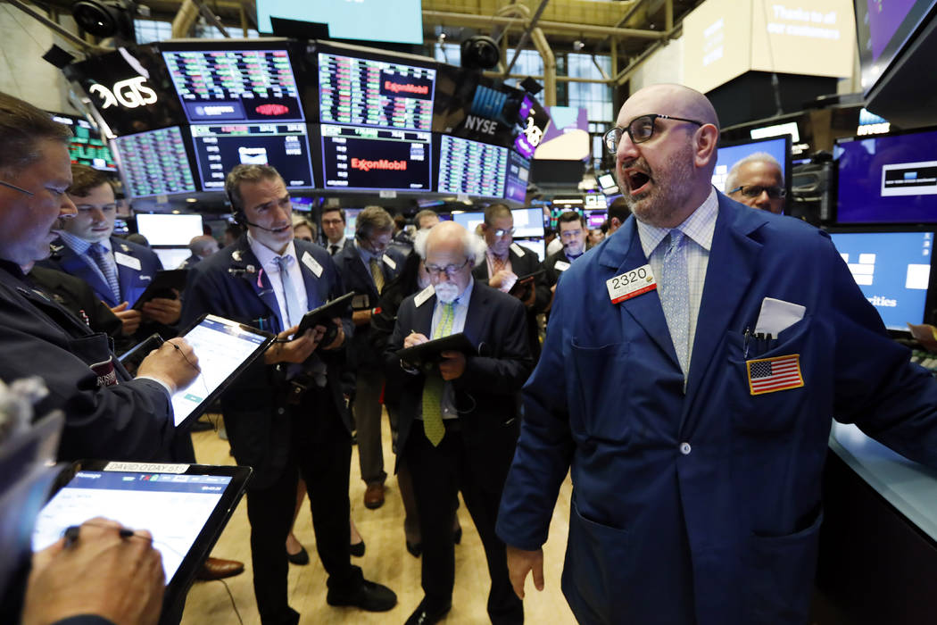 Specialist Peter Giacchi, right, calls out prices on the New York Stock Exchange trading floor ...