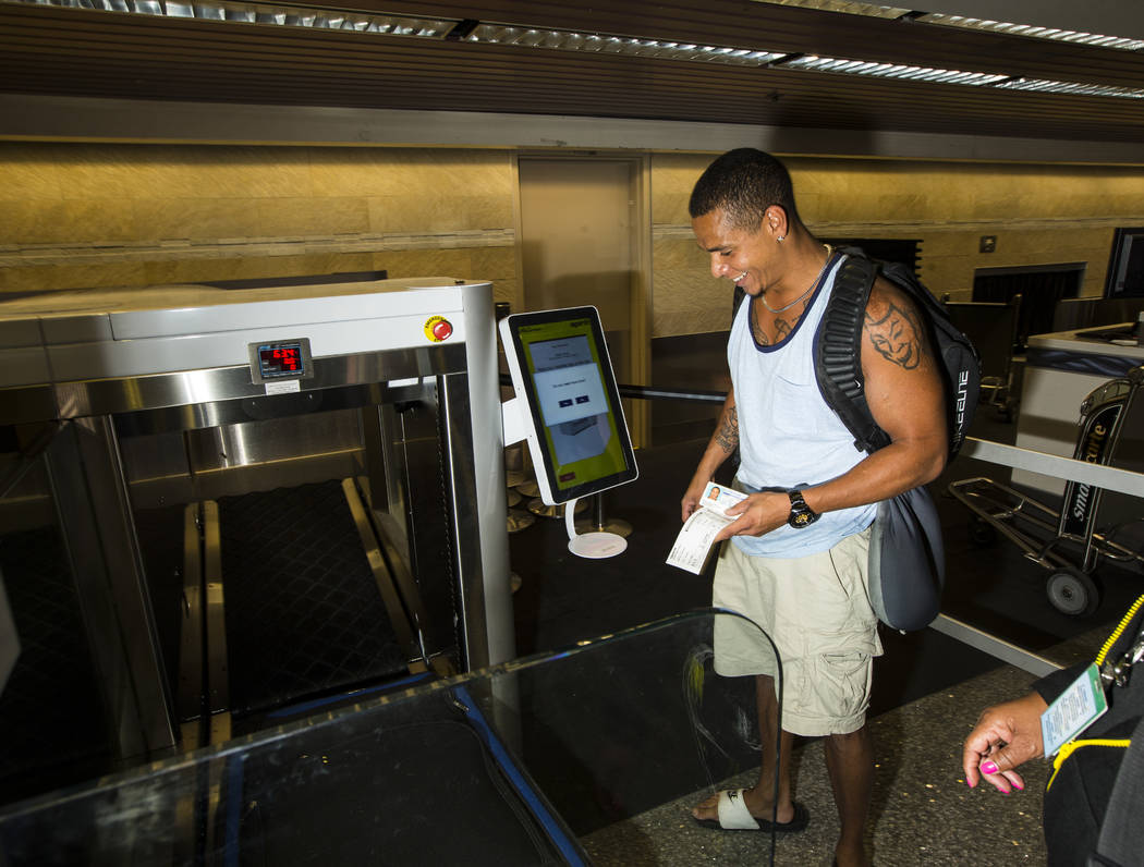 Jerrel Oneal of Beaverton, Oregon, uses the Spirit Airlines automated self-service bag drop sys ...