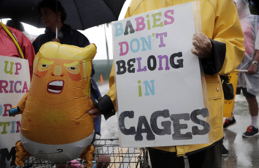 Protesters hold an inflatable doll in the likeness of President Donald Trump outside of the Hom ...