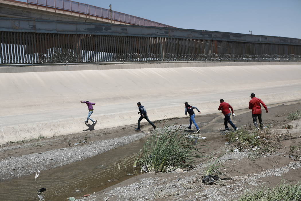 FILE - In this June 15, 2019, file photo, migrants cross the Rio Bravo illegally to surrender t ...