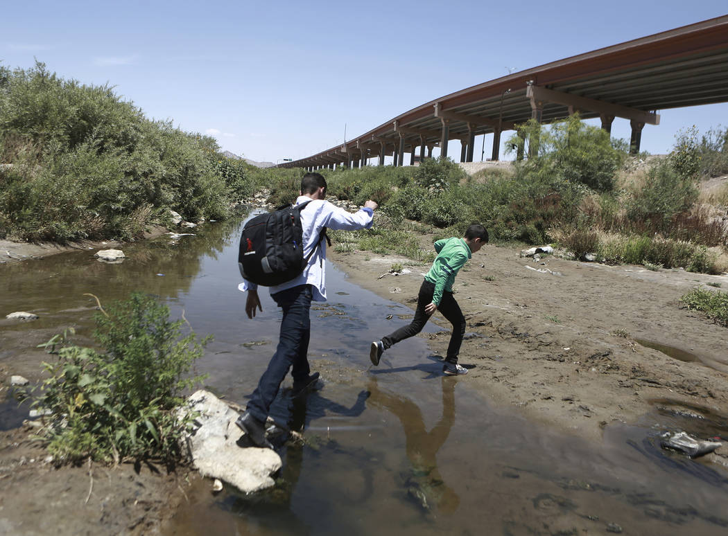 FILE - In this June 7, 2019, file photo, people cross the Rio Grande into the United States to ...