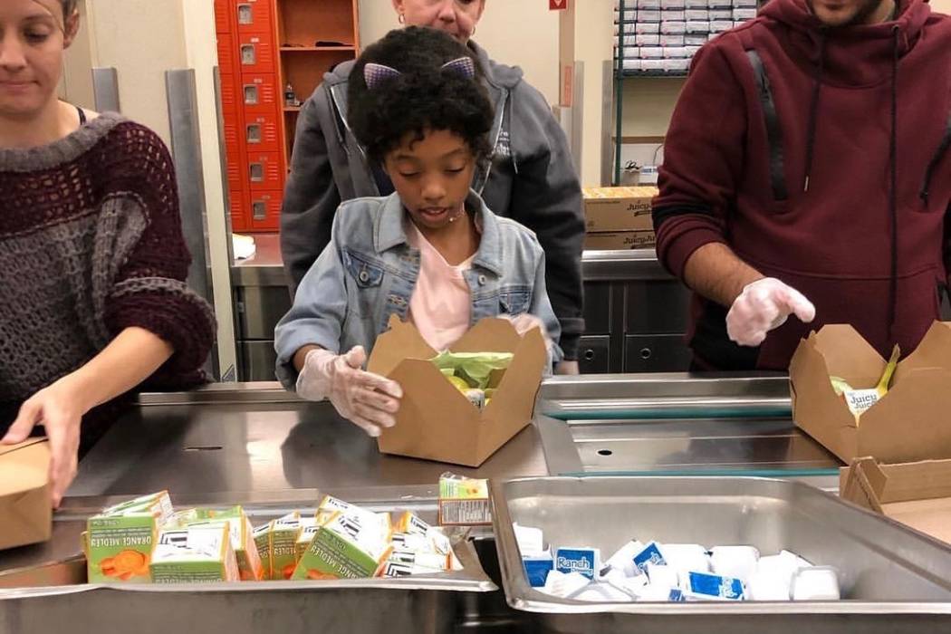 Jordyn Lenae, 11, helps pack lunches at Three Square. Jordyn said she believes every child shou ...