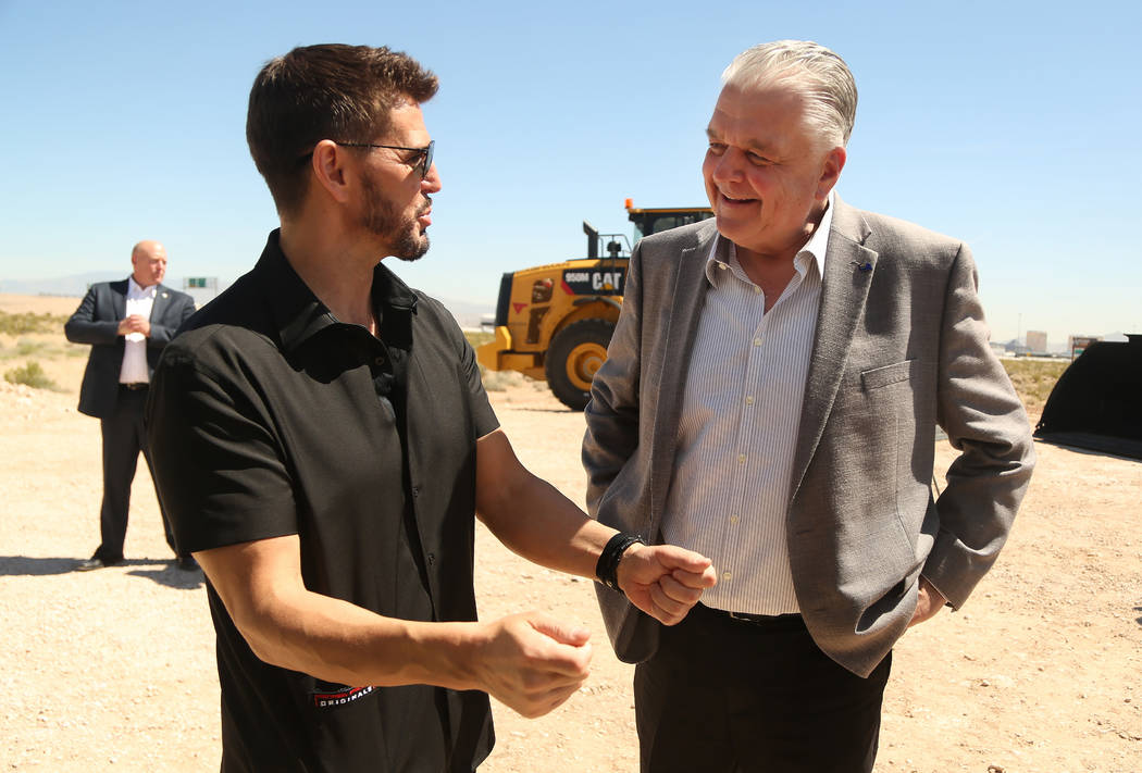 CEO of Switch Rob Roy, left, talks with Nevada Governor Steve Sisolak, right, during the ground ...