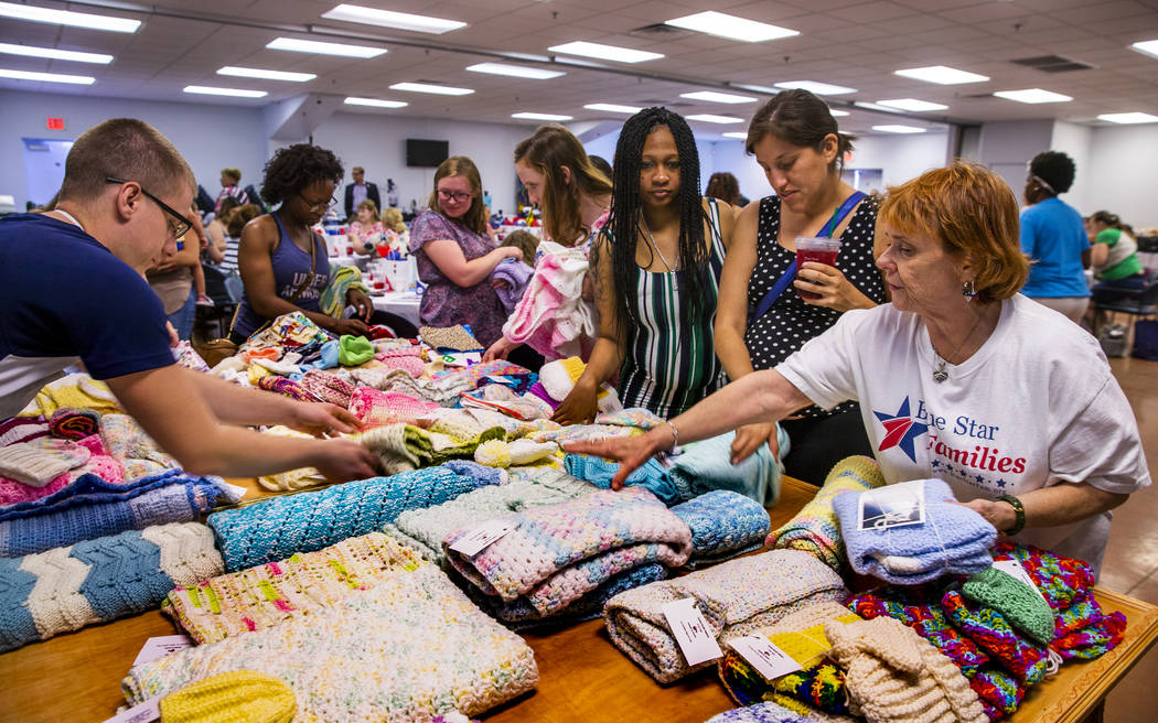 Roseann Voigt, with the Twisted Needle Knockers, right, points out all the free blankets and ot ...