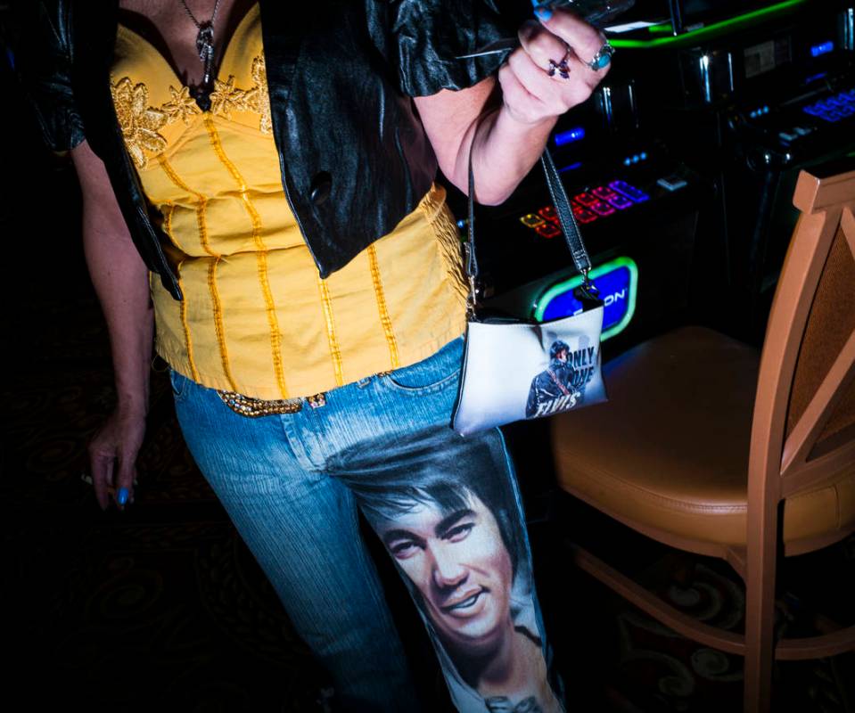 Elvis fan Jeanie Pusser shows off her custom denim and bag before attending the '70s era showca ...