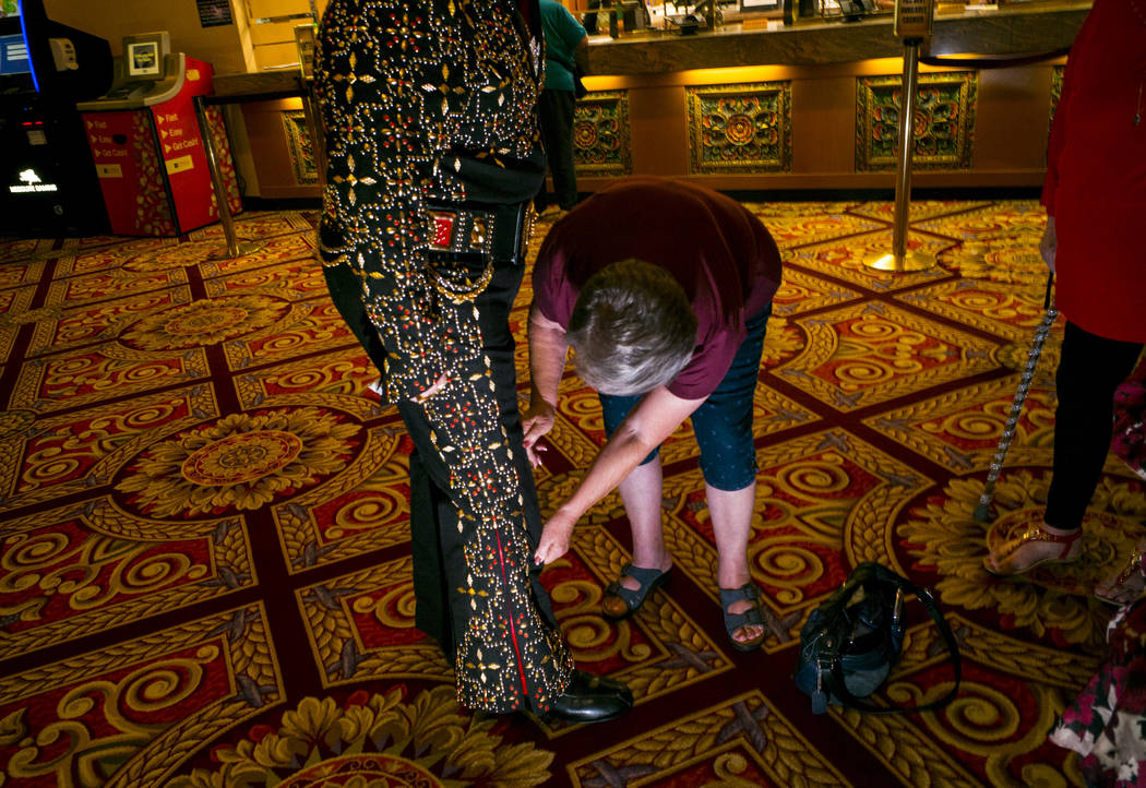 Carol Park, of Modesto, Calif., right, helps adjust the jumpsuit of Elvis tribute artist Clovis ...