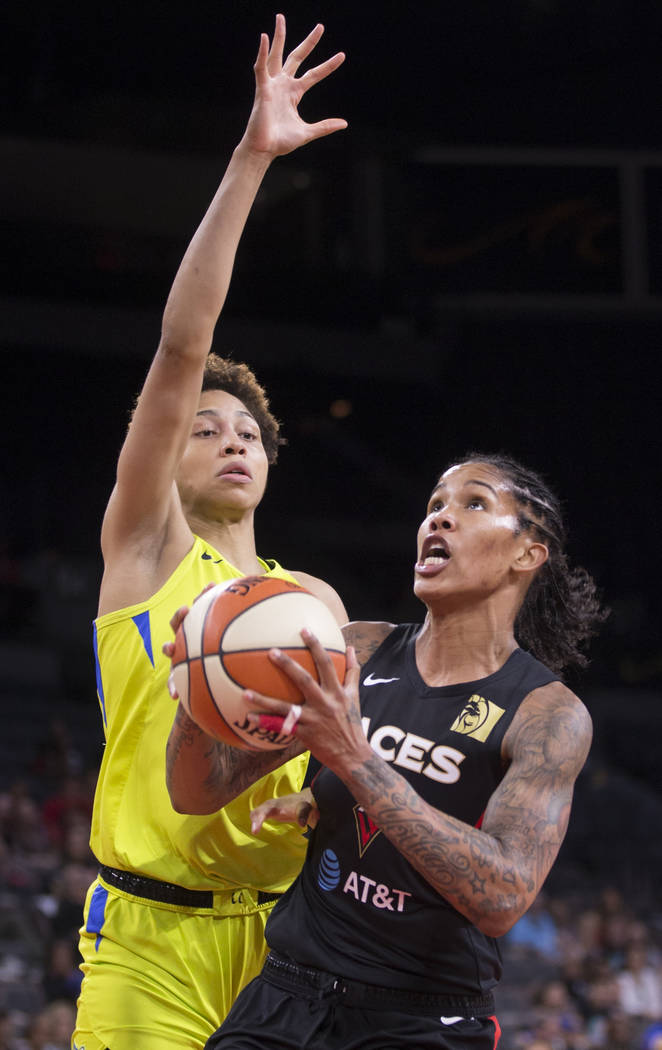 Las Vegas Aces forward Tamera Young (1) drives past Dallas Wings forward Isabelle Harrison (20) ...