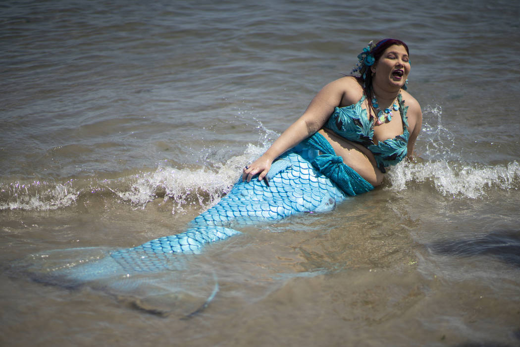 A parade attendee in costume refreshes herself at the sea during the 37th annual Mermaid Parade ...