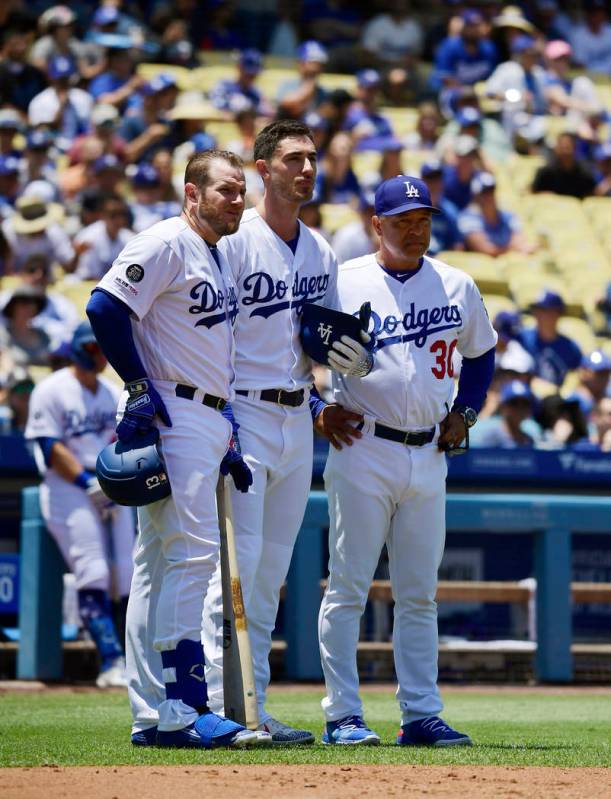 Los Angeles Dodgers Max Muncy, left, stand with Cody Bellinger, center, and manager Dave Robert ...