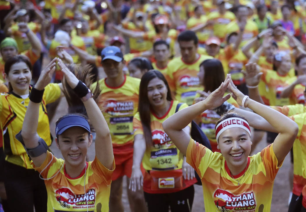 Runners warn up before the start of a marathon and biking event in Mae Sai, Chiang Rai province ...