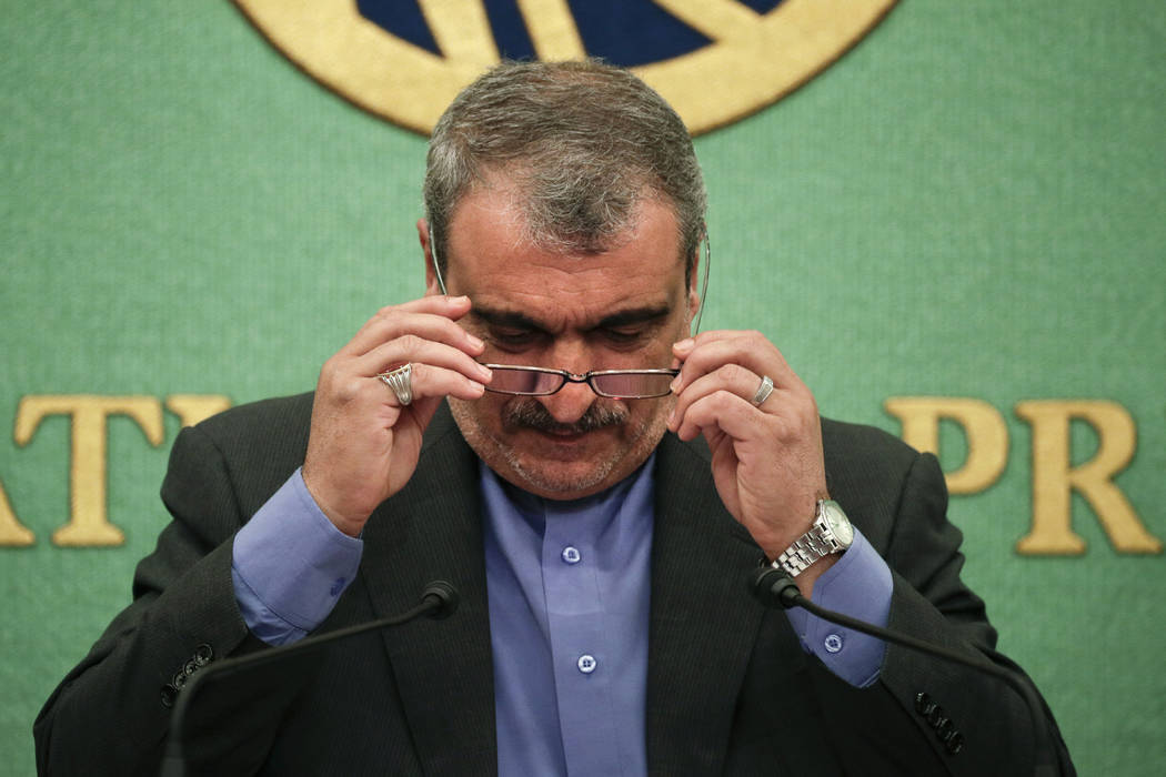 Iranian Ambassador to Japan Morteza Rahmani Movahed puts on his reading glasses before speaking ...