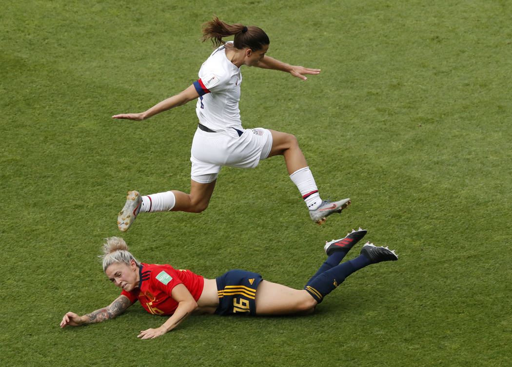 United States' Tobin Heath, top, jumps over Spain's Maria Leon during the Women's World Cup rou ...