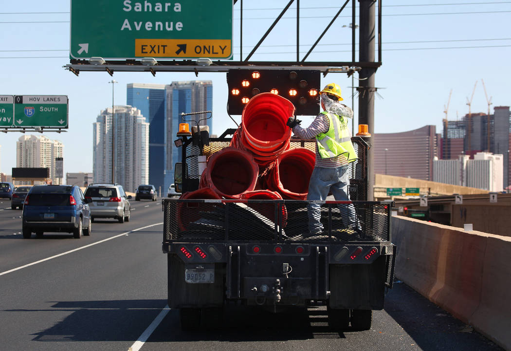 Crews work to remove orange safety barrels along Interstate 15 near the Sahara Avenue exit on M ...