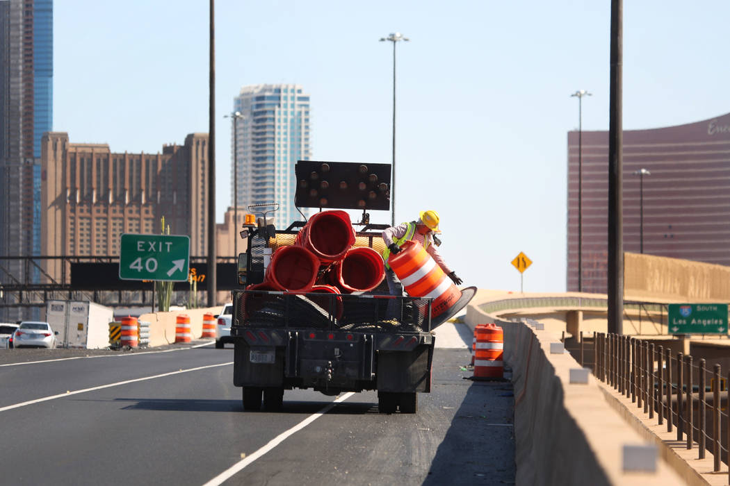 Crews work to remove orange safety barrels along Interstate 15 near the Sahara Avenue exit on M ...