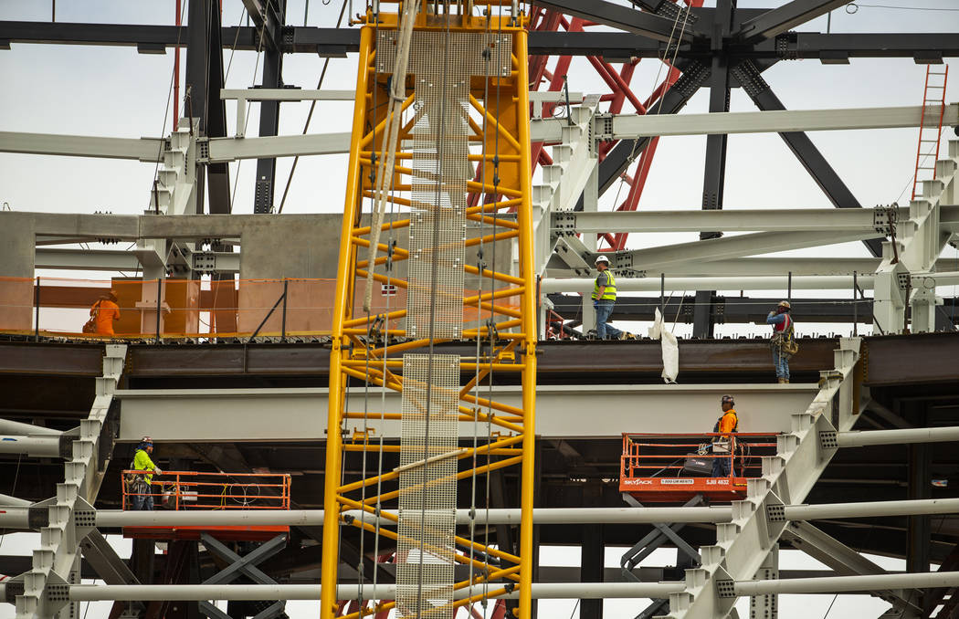 Steelworkers maneuver about the interior of the Raiders Stadium as construction continues on Tu ...