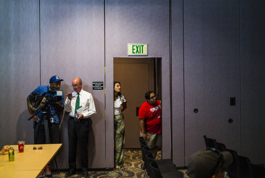 UNLV students Lynnette Hull, center, and Max Gonzalz, right, watch the Democratic presidential ...